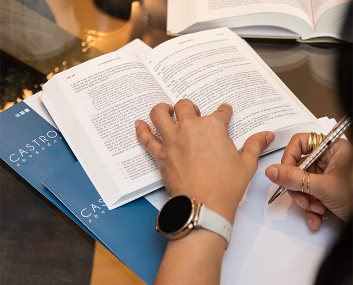 Persona leyendo un folleto informativo de Castro Abogados