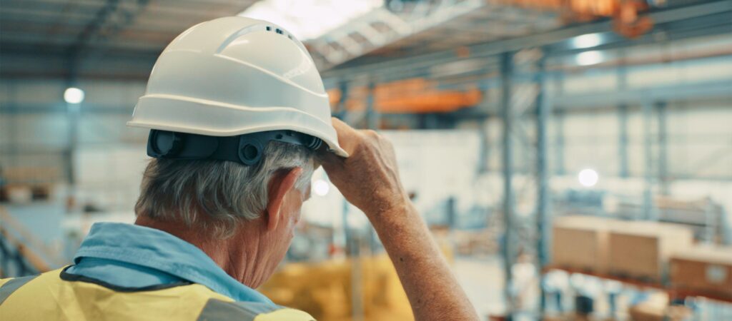 Trabajador con casco en una nave industrial, derecho laboral en Mallorca