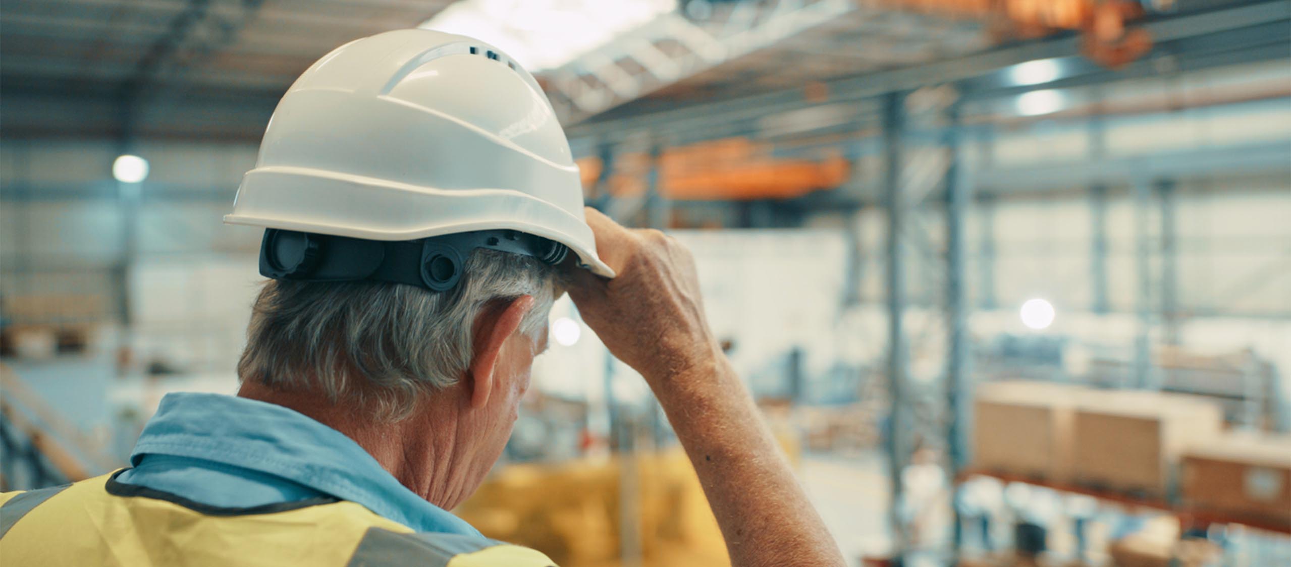 Trabajador con casco en una nave industrial, derecho laboral en Mallorca